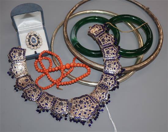 An Indian enamelled white metal necklace, coral bead strand, paste ring, bangles and neck rings.